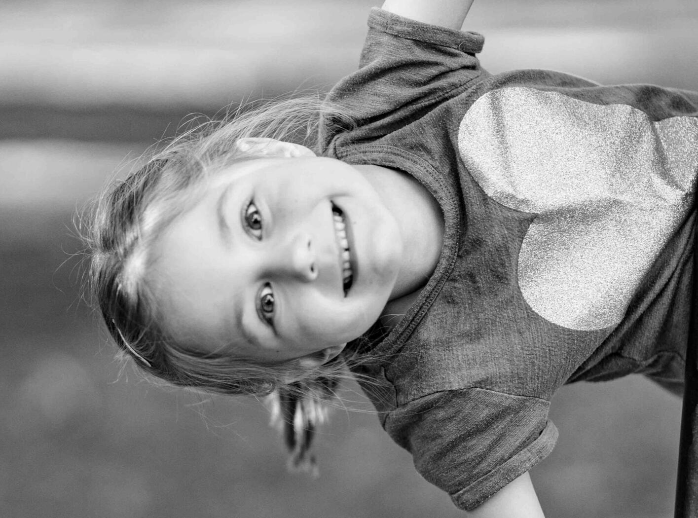 A child smiles while lying in the grass